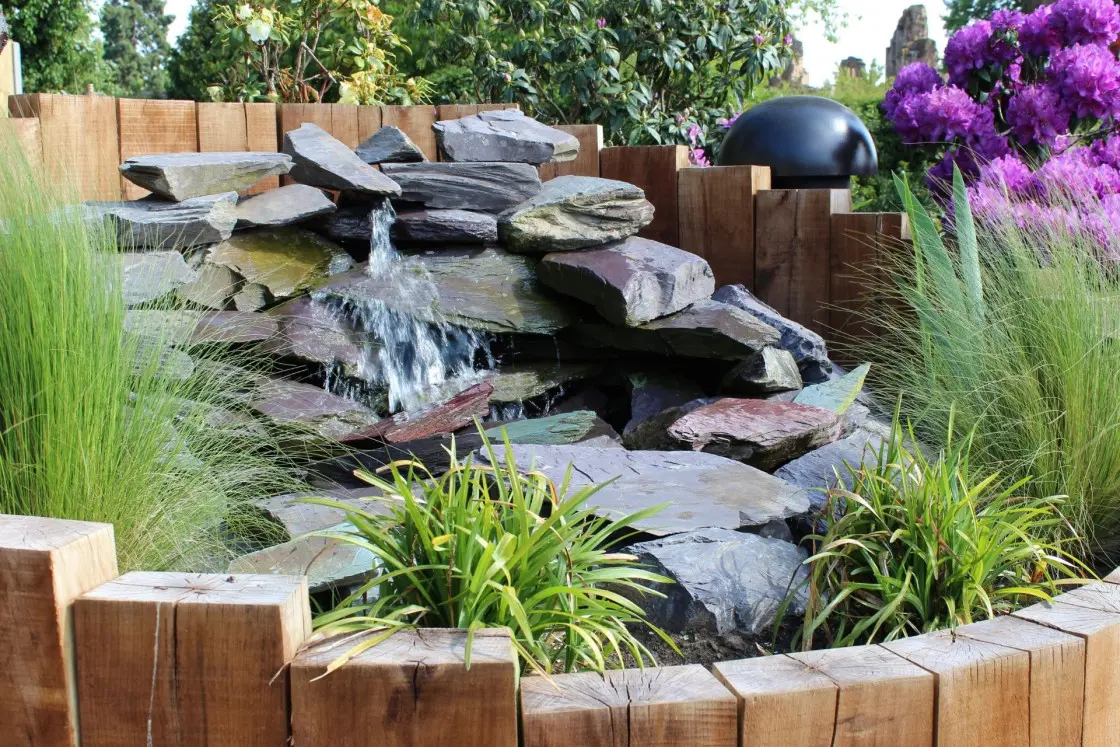 Natural slate water feature in raised timber bed